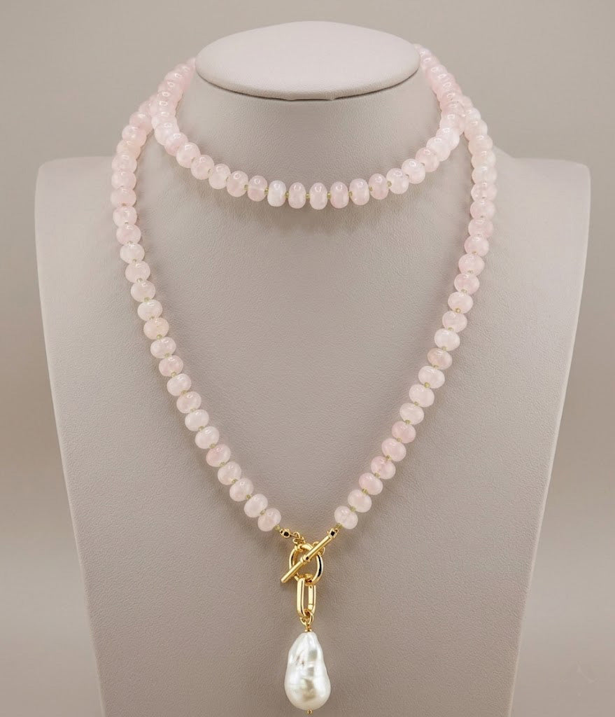 Long rose quartz necklace with peridot accents and a baroque pearl drop, shown full length