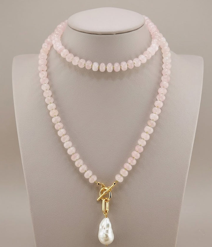 Long rose quartz necklace with peridot accents and a baroque pearl drop, shown full length