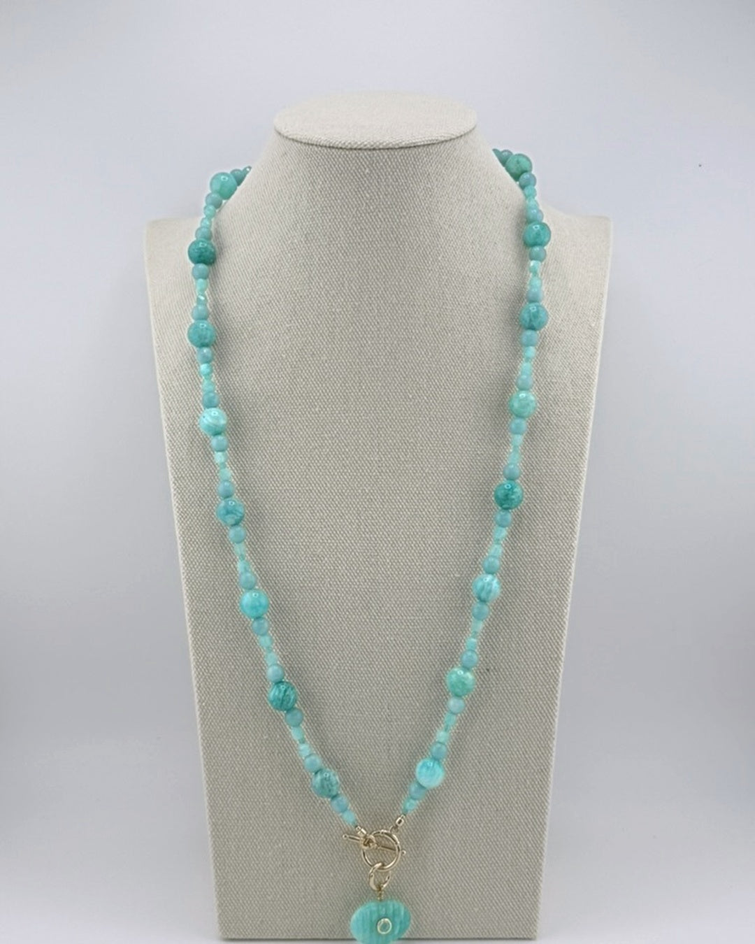 Long amazonite bubble necklace with a carved amazonite oval pendant, full view on a display bust