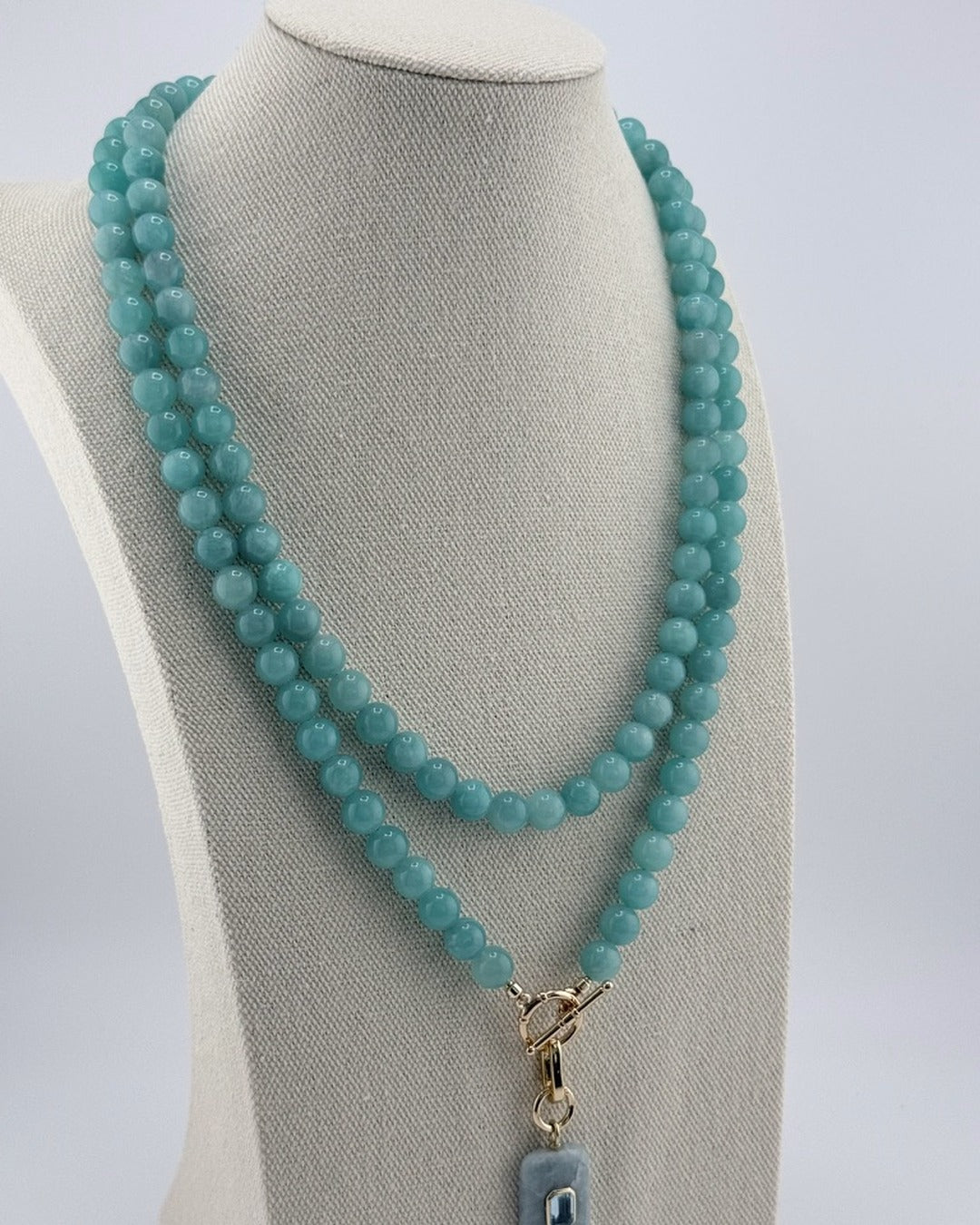 Angled view of the amazonite long necklace with the aquamarine and blue topaz pendant