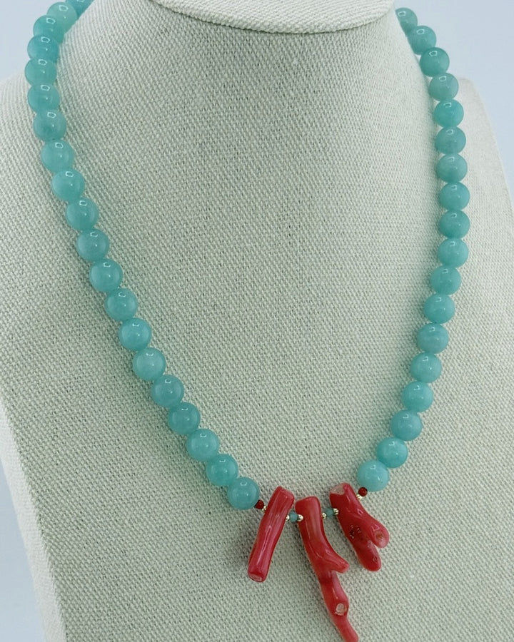 Amazonite and coral necklace, angled view showing the aqua strand and coral cluster