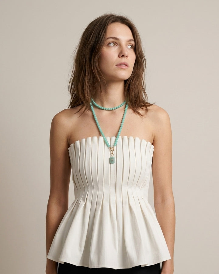 Model in a white pleated top wearing the long amazonite and aquamarine pendant necklace doubled