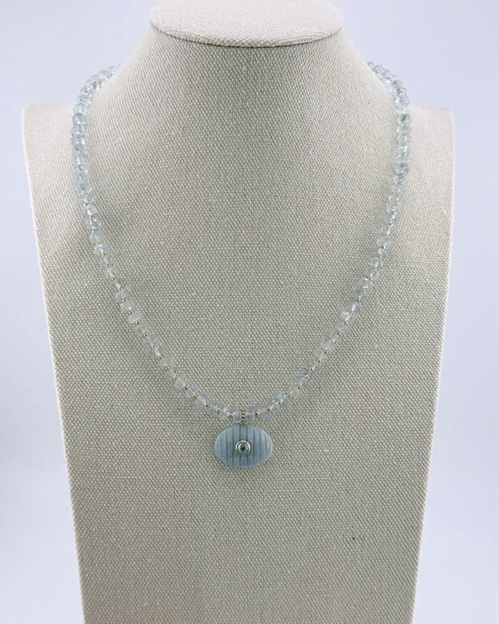 Aquamarine pendant necklace, front view showing the pale faceted beads and gold accents