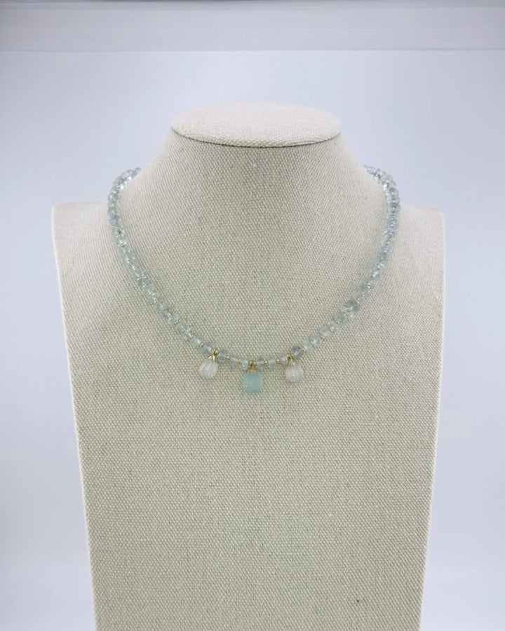 Pale aquamarine necklace with three carved teardrop drops at the front, full view on a display bust
