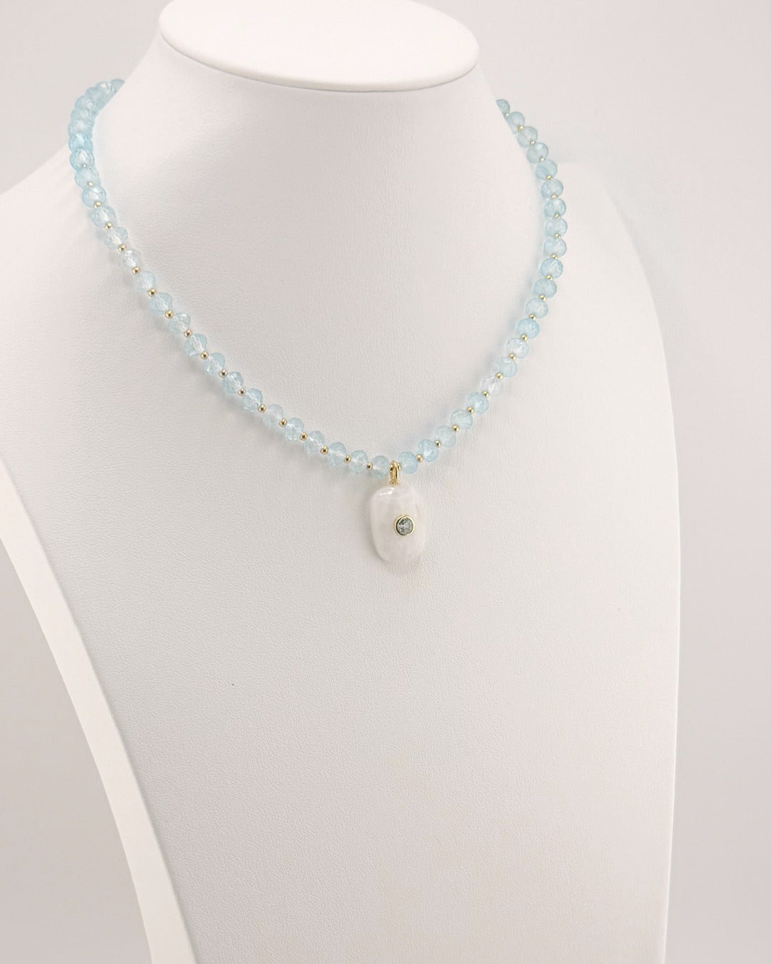 Angled view of the blue topaz and moonstone pendant necklace
