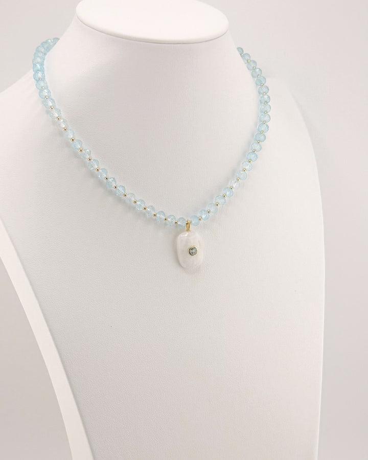 Angled view of the blue topaz and moonstone pendant necklace