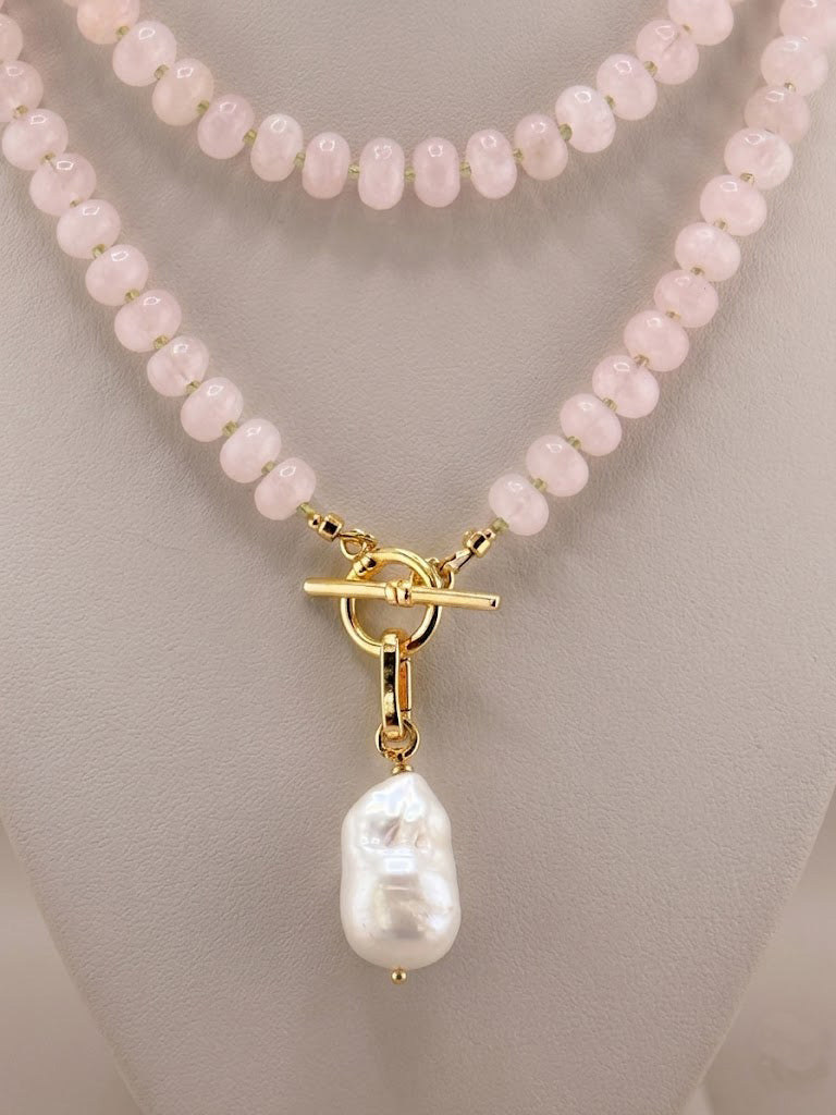Close-up of faceted peridot accents and a baroque pearl on the rose quartz necklace