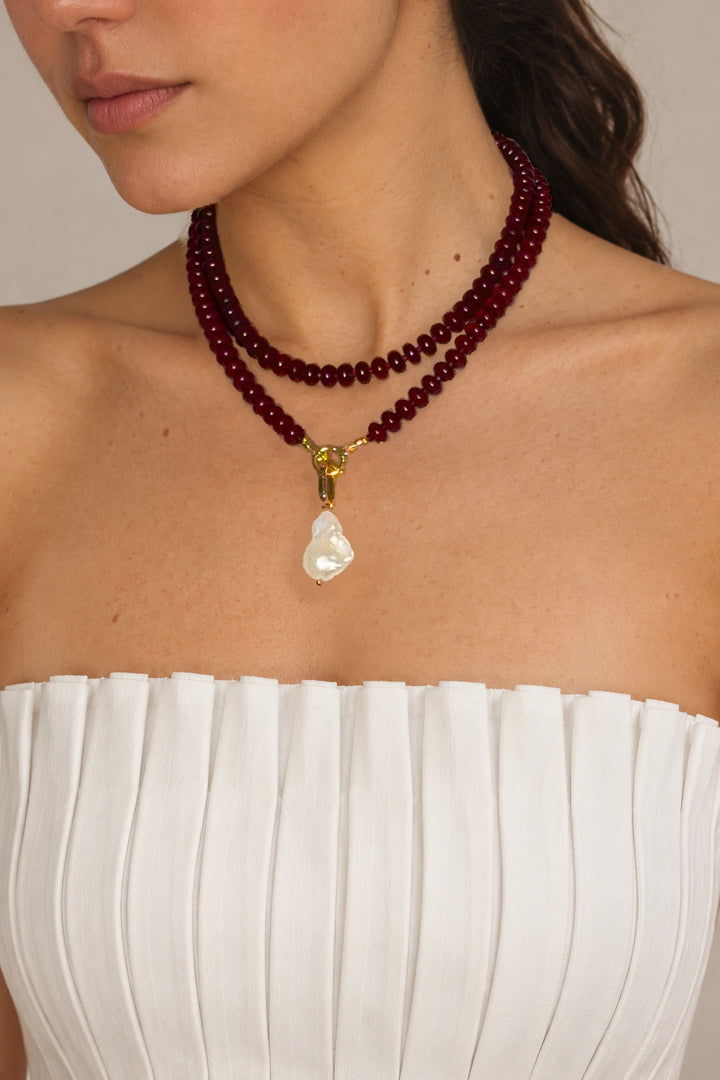 Lulu Necklace in Burgundy worn doubled with the pearl charm, model with head turned