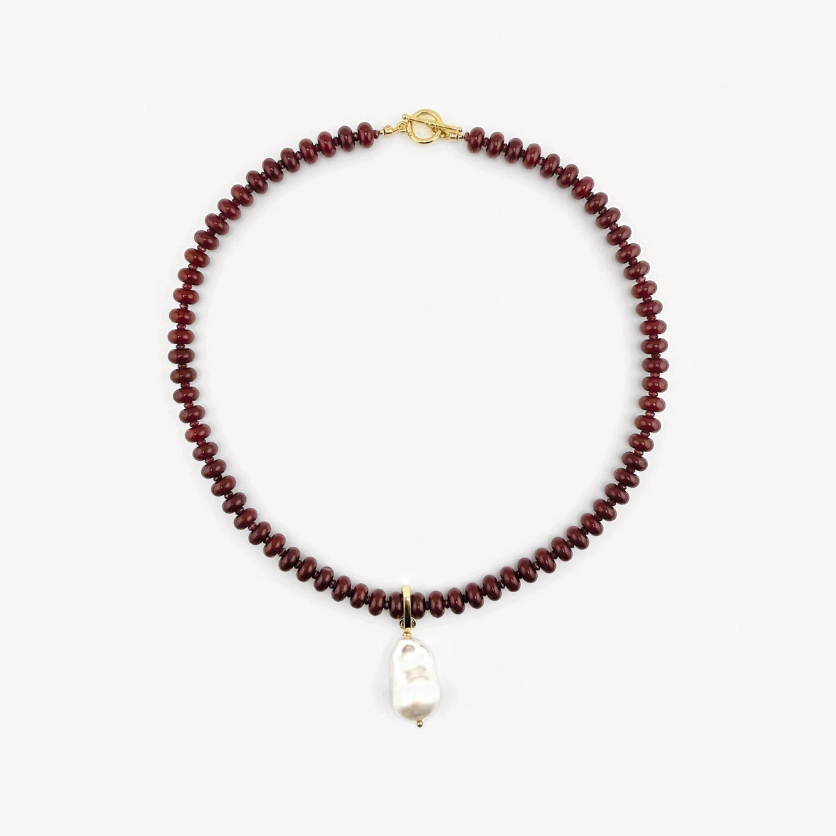Lulu Necklace in Burgundy with garnet accents and a gold toggle, shown with the cultured baroque pearl charm