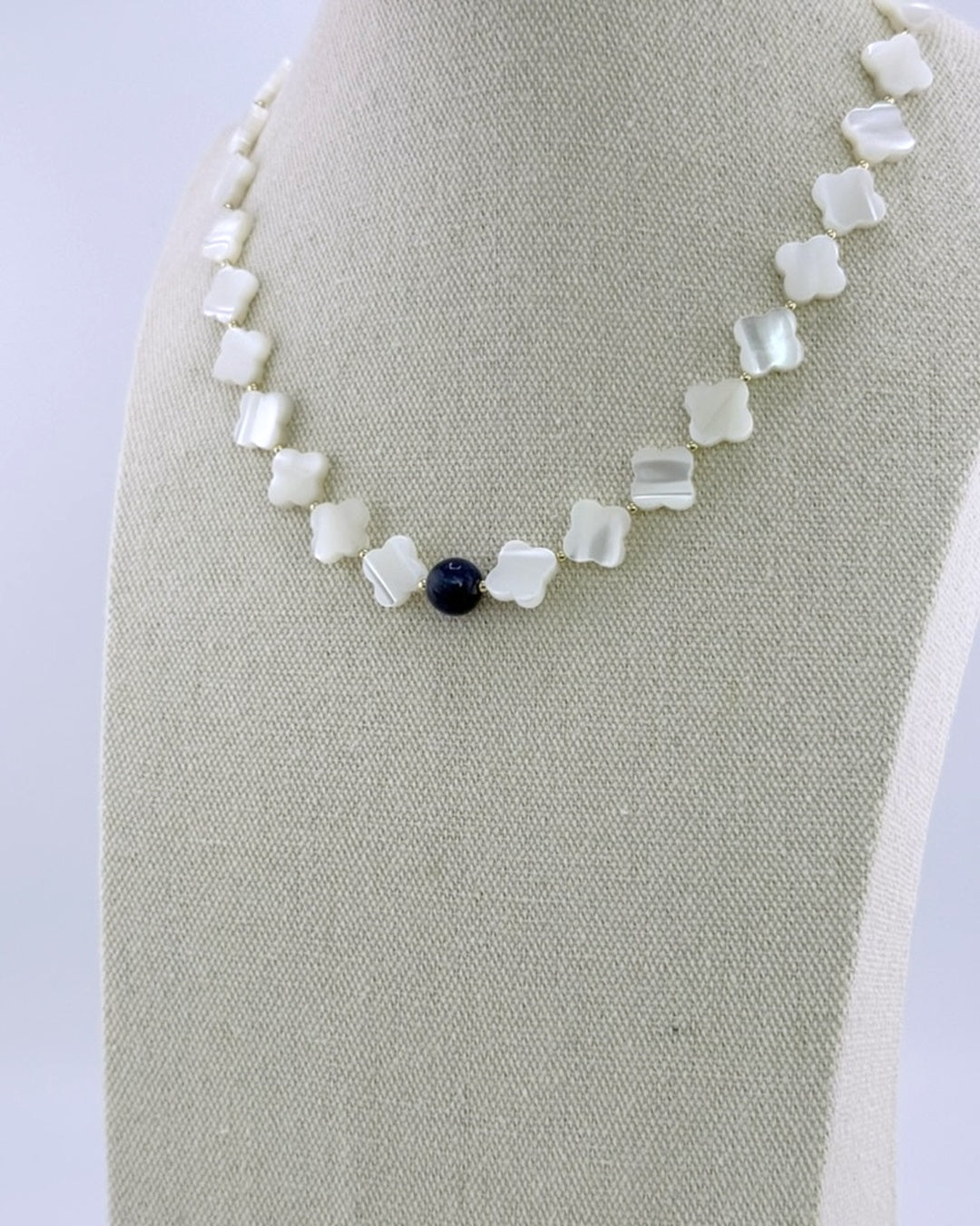 Mother of pearl and kyanite necklace, angled view on the display bust