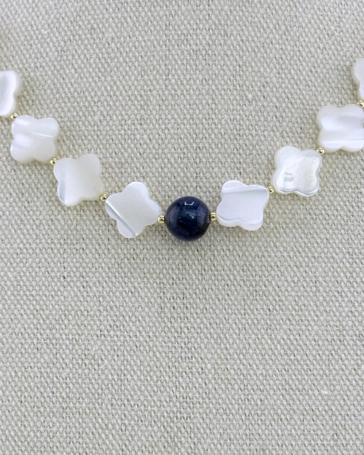 Close-up macro of the pearlescent mother of pearl clover beads and the deep-blue kyanite center bead