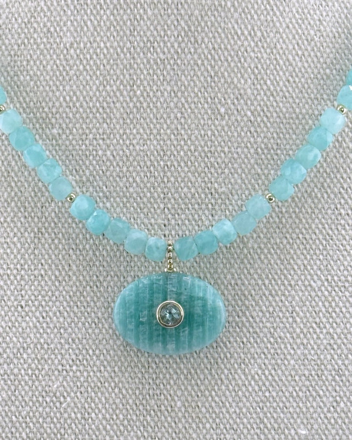 Detail of the carved amazonite oval pendant set with a blue topaz on the 4mm amazonite cube strand