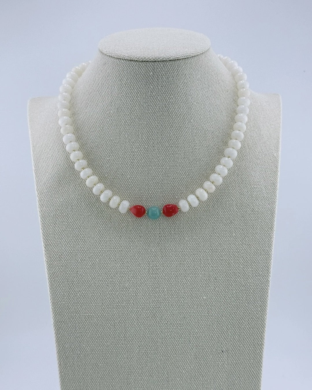 White jade necklace with gold accents and a coral-and-amazonite center, front view