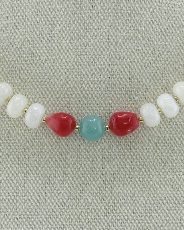 Close-up of the pomegranate bamboo coral and amazonite center on the white jade necklace