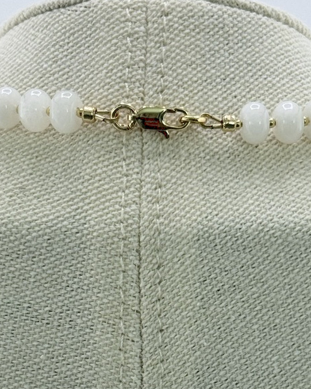 Back view showing the gold lobster clasp on the white jade necklace